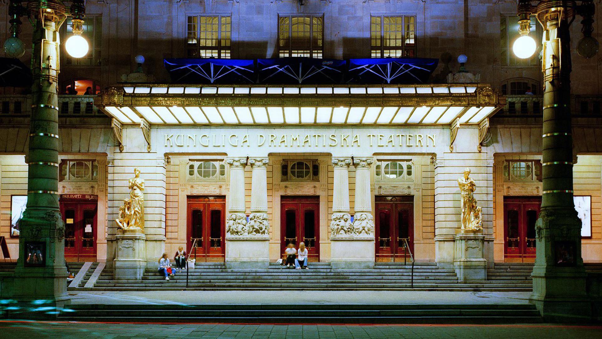 Ett mindre sällskap sitter på Dramatentrappan.