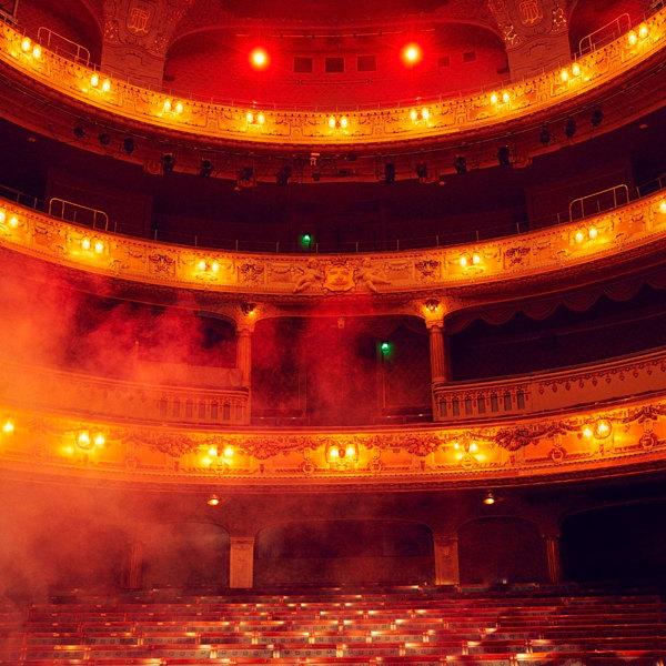 Rök ligger över Stora scenen som är upplyst i rött.