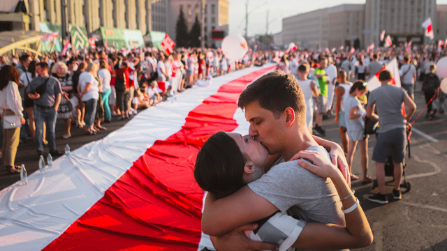 En man och en kvinna kysser varandra under protesterna på Belarus gator.