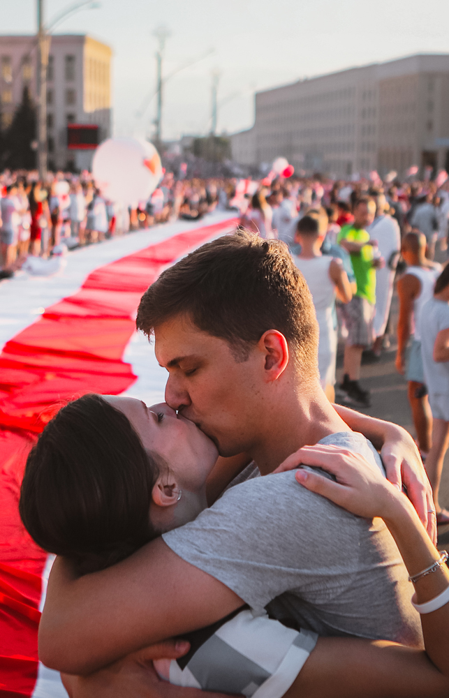 En man och en kvinna kysser varandra under protesterna på Belarus gator.